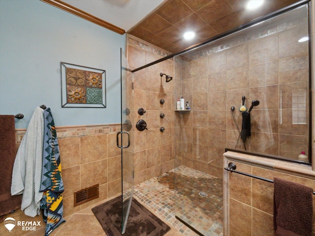 9705 Burning Tree Dr, Grand Blanc, MI 48439 - bathroom featuring a tile shower, crown molding, recessed lighting, tile walls, and wainscoting