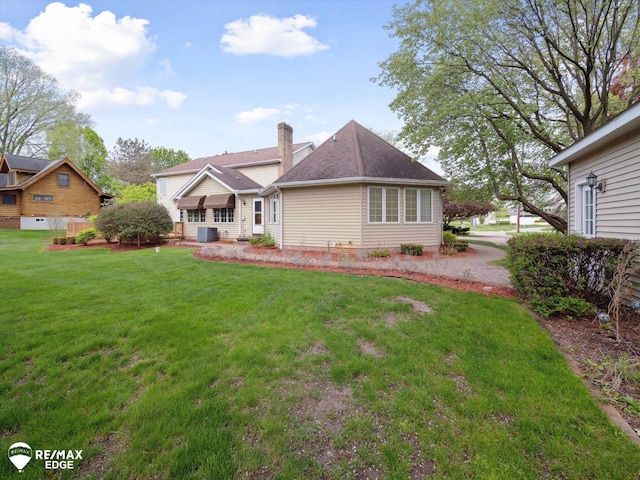 9705 Burning Tree Dr, Grand Blanc, MI 48439 - rear view of house featuring a yard and a chimney