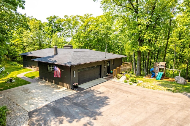 8680 Bennett St SE, Ada, MI 49301 - view of front of house featuring roof with shingles, asphalt driveway, a garage, a chimney, and a wooden deck