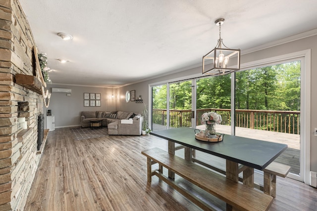8680 Bennett St SE, Ada, MI 49301 - dining space with a wall unit AC, wood finished floors, crown molding, baseboards, and a chandelier