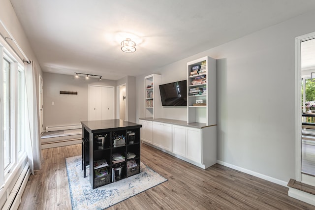 8680 Bennett St SE, Ada, MI 49301 - dining room featuring wood finished floors, a baseboard heating unit, baseboards, and baseboard heating