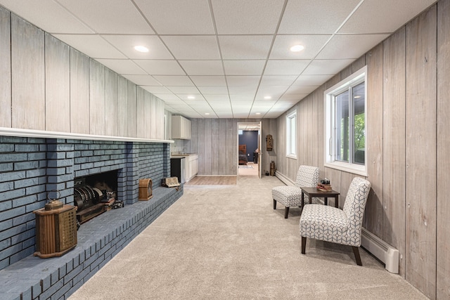 8680 Bennett St SE, Ada, MI 49301 - living area with light carpet, a baseboard heating unit, wooden walls, recessed lighting, and a fireplace