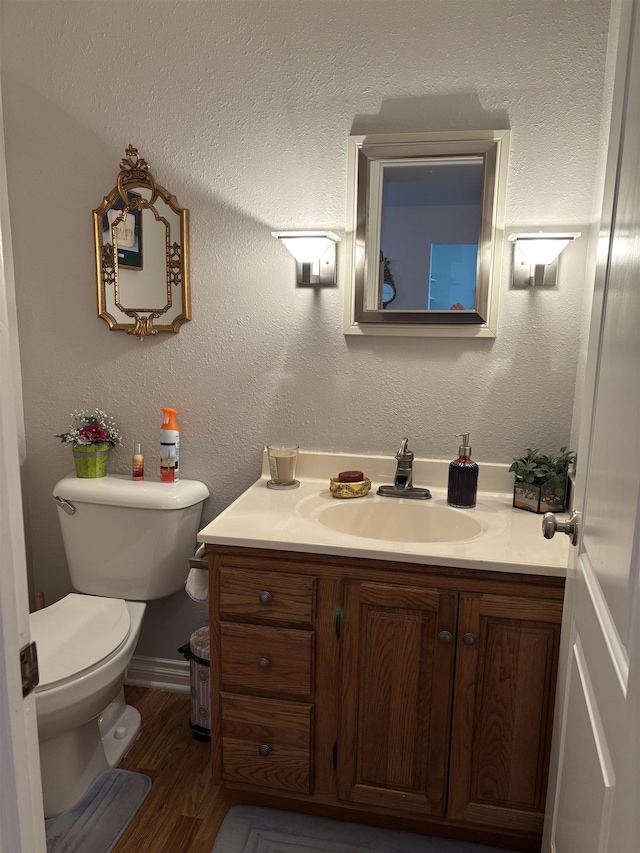 249 Churchgrove Rd, Frankenmuth, MI 48734 - bathroom with vanity, toilet, wood finished floors, and baseboards