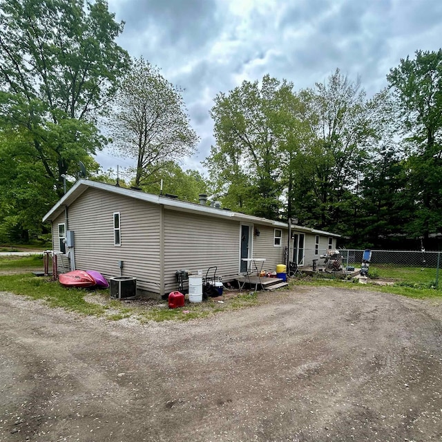4109 N Maplecrest Dr, Sanford, MI 48657 - view of home's exterior featuring view of scattered trees and cooling unit