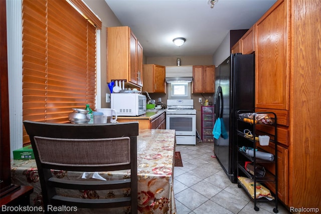 20811 Doepfer Rd, Warren, MI 48091 - kitchen featuring white appliances, light countertops, light tile patterned floors, brown cabinetry, and wall chimney range hood