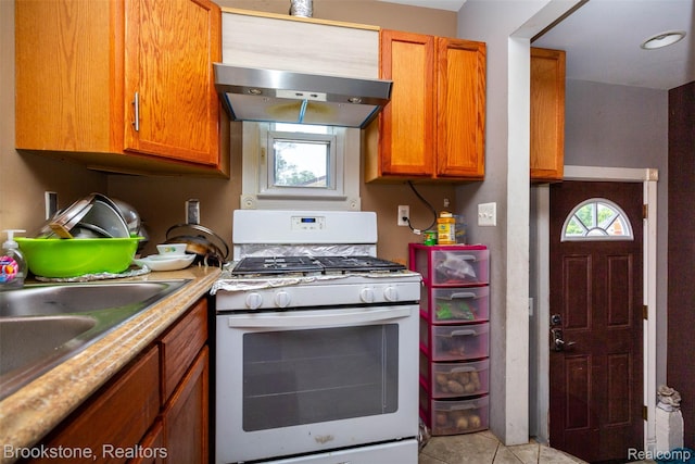20811 Doepfer Rd, Warren, MI 48091 - kitchen featuring white gas range, under cabinet range hood, brown cabinetry, and light countertops