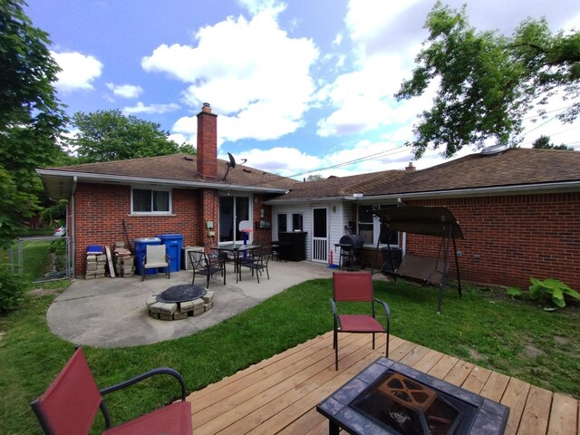 8383 Dixie Ln, Dearborn Heights, MI 48127 - back of house featuring a fire pit, a deck, a chimney, brick siding, and a patio