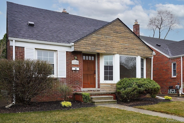 15400 Sprenger Ave, Eastpointe, MI 48021 - view of front of property featuring a chimney, brick siding, a shingled roof, and stone siding