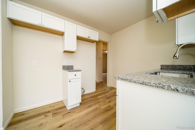 15400 Sprenger Ave, Eastpointe, MI 48021 - kitchen with a sink, light wood-type flooring, light stone counters, white cabinetry, and baseboards