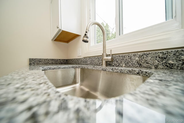 15400 Sprenger Ave, Eastpointe, MI 48021 - kitchen view of a sink, white cabinets, and light stone countertops
