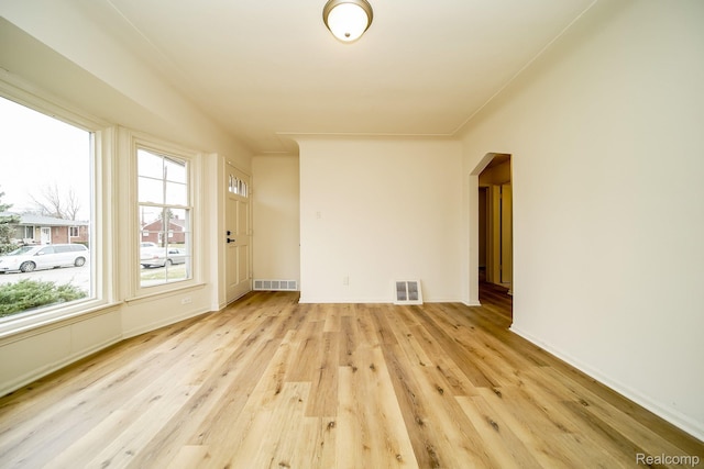 15400 Sprenger Ave, Eastpointe, MI 48021 - empty room featuring arched walkways, healthy amount of natural light, light wood finished floors, and baseboards