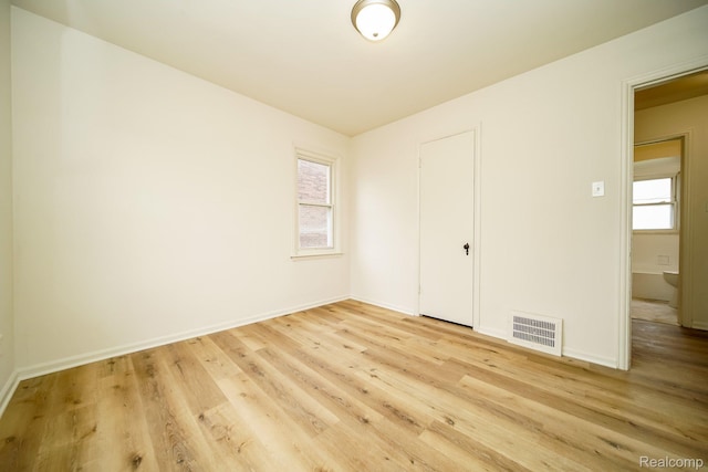 15400 Sprenger Ave, Eastpointe, MI 48021 - unfurnished bedroom with multiple windows, light wood finished floors, and baseboards