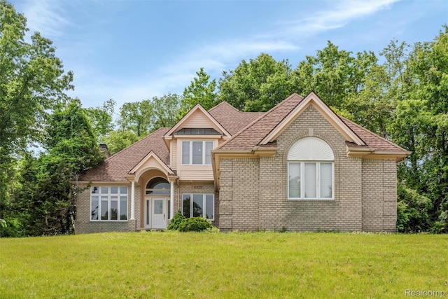 2479 Waterfront Dr, Brighton, MI 48114 - view of front of house with brick siding, a front lawn, and a shingled roof
