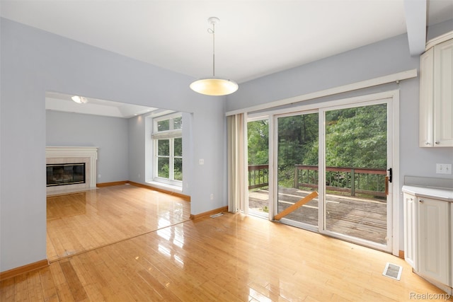 2479 Waterfront Dr, Brighton, MI 48114 - unfurnished living room featuring light wood finished floors, a premium fireplace, and baseboards
