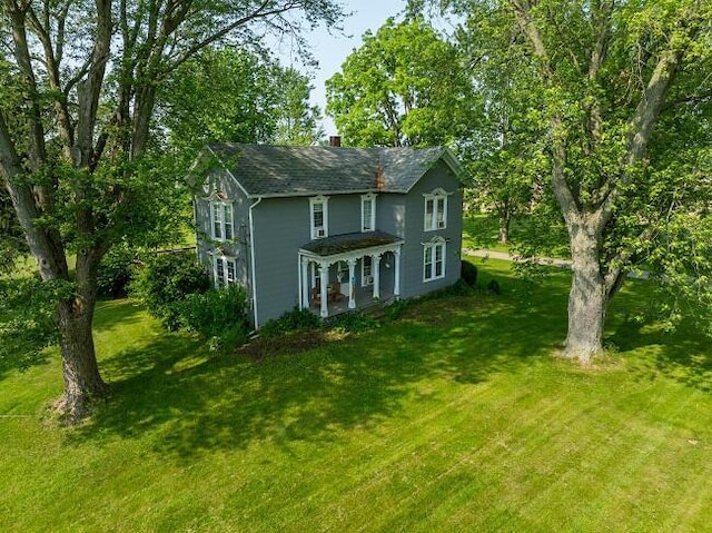 888 E Saint Joe Hwy, Grand Ledge, MI 48837 - view of front of house featuring a front yard, a chimney, and roof with shingles