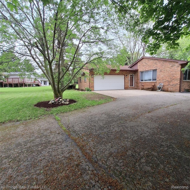 3827 Woodland Dr, Metamora, MI 48455 - single story home featuring a garage, a front yard, concrete driveway, and brick siding
