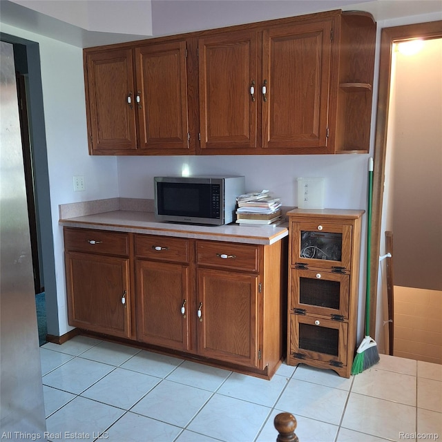 3827 Woodland Dr, Metamora, MI 48455 - kitchen featuring stainless steel microwave, light countertops, light tile patterned flooring, and open shelves