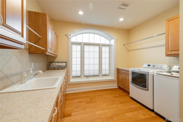 6312 S Graham Rd, Saint Charles, MI 48655 - washroom with cabinet space, washer and clothes dryer, light wood-style floors, and recessed lighting