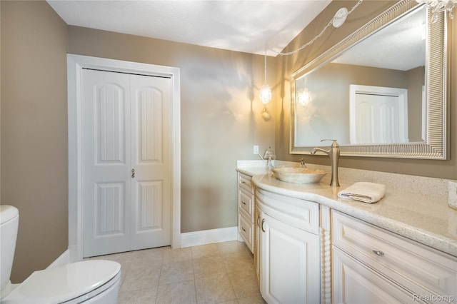 6312 S Graham Rd, Saint Charles, MI 48655 - bathroom featuring toilet, vanity, tile patterned flooring, a closet, and baseboards
