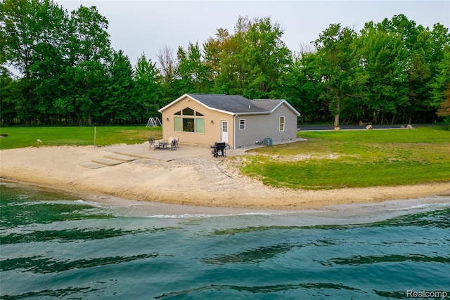 6312 S Graham Rd, Saint Charles, MI 48655 - back of house featuring view of water and beach, a lawn, and a patio