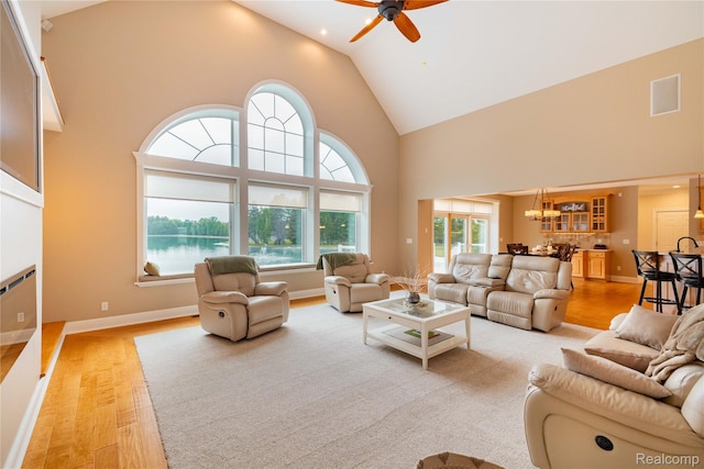 6312 S Graham Rd, Saint Charles, MI 48655 - living area with high vaulted ceiling, healthy amount of natural light, a ceiling fan, light wood-type flooring, and a chandelier