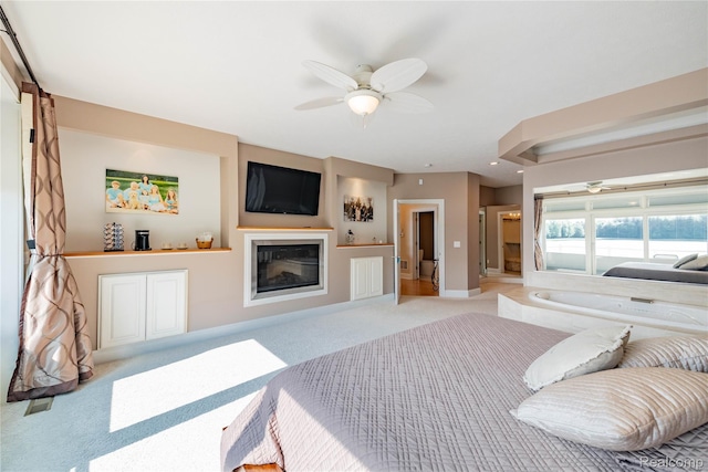 6312 S Graham Rd, Saint Charles, MI 48655 - carpeted bedroom featuring a glass covered fireplace, baseboards, and ceiling fan