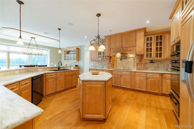 6312 S Graham Rd, Saint Charles, MI 48655 - kitchen featuring black appliances, a sink, a kitchen island, light wood-style flooring, and backsplash