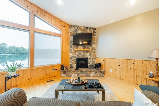 6312 S Graham Rd, Saint Charles, MI 48655 - living area with healthy amount of natural light, wooden walls, a stone fireplace, wood finished floors, and recessed lighting