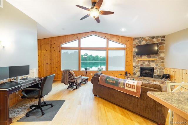 6312 S Graham Rd, Saint Charles, MI 48655 - living room with wood walls, light wood-style floors, ceiling fan, a desk, and a stone fireplace