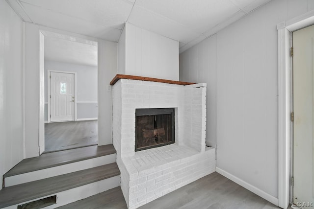 603 Company St, Adrian, MI 49221 - unfurnished living room with wood finished floors and a brick fireplace