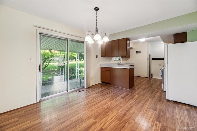 229 Hillview Ter, Fenton, MI 48430 - kitchen with freestanding refrigerator, light wood-type flooring, light countertops, a chandelier, and decorative light fixtures