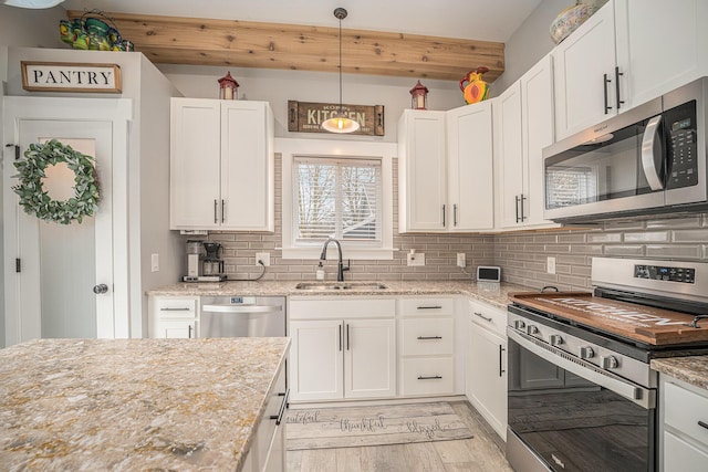 1749 Fairview Dr, Allegan, MI 49010 - kitchen with appliances with stainless steel finishes, a sink, white cabinets, and light wood-style floors