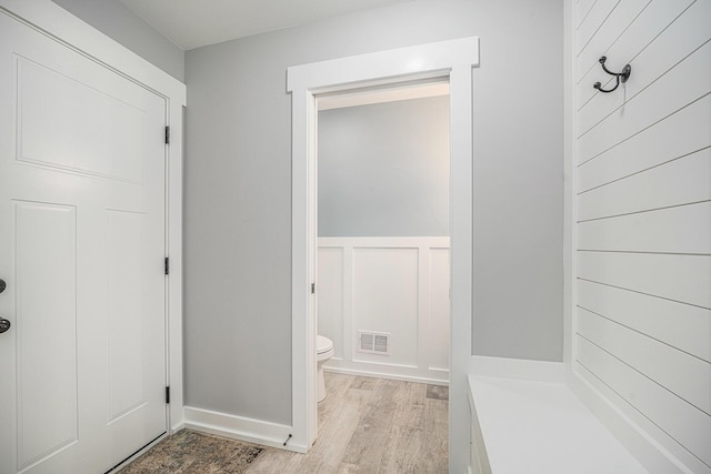 1749 Fairview Dr, Allegan, MI 49010 - bathroom with wood finished floors, toilet, a wainscoted wall, and baseboards