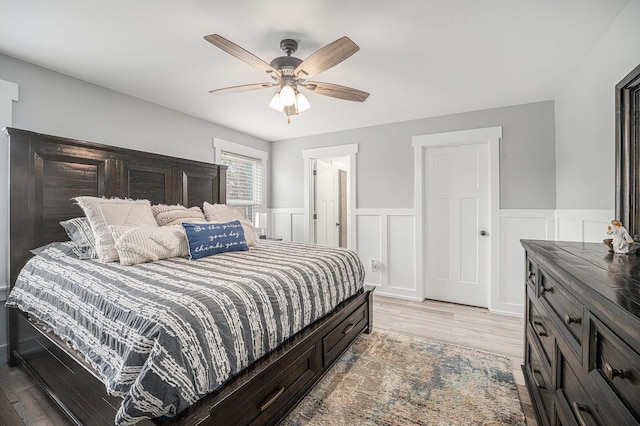 1749 Fairview Dr, Allegan, MI 49010 - bedroom with light wood-type flooring, a wainscoted wall, and a ceiling fan