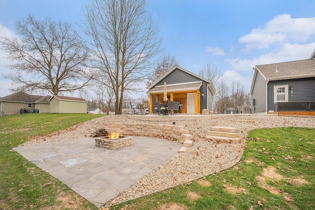 1749 Fairview Dr, Allegan, MI 49010 - rear view of house with an outdoor fire pit, a patio area, and a yard