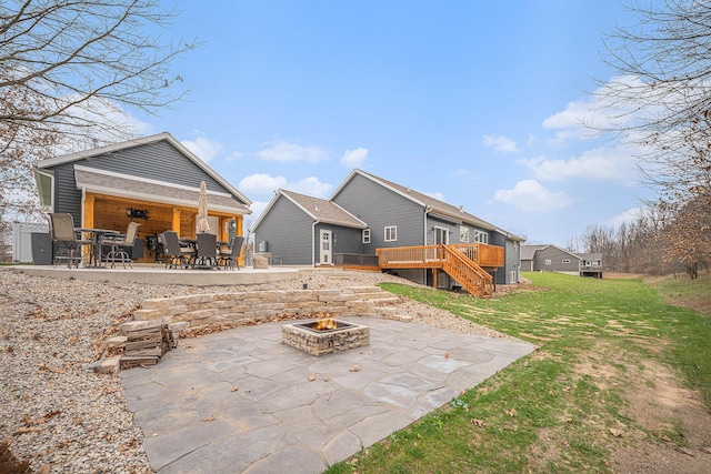 1749 Fairview Dr, Allegan, MI 49010 - back of property with an outdoor fire pit, a patio area, a wooden deck, and stairs