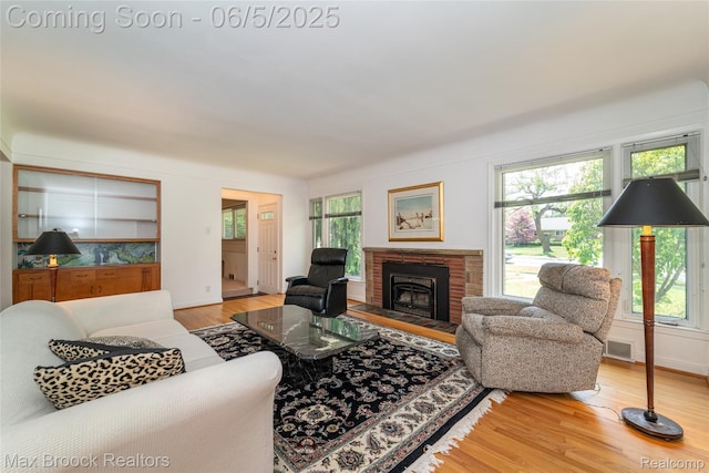 16926 Beverly Rd, Beverly Hills, MI 48025 - living room featuring wood finished floors, a brick fireplace, and baseboards
