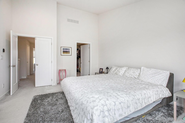 2990 Stoke Way, Ann Arbor, MI 48105 - bedroom featuring baseboards, light carpet, a towering ceiling, a closet, and a spacious closet