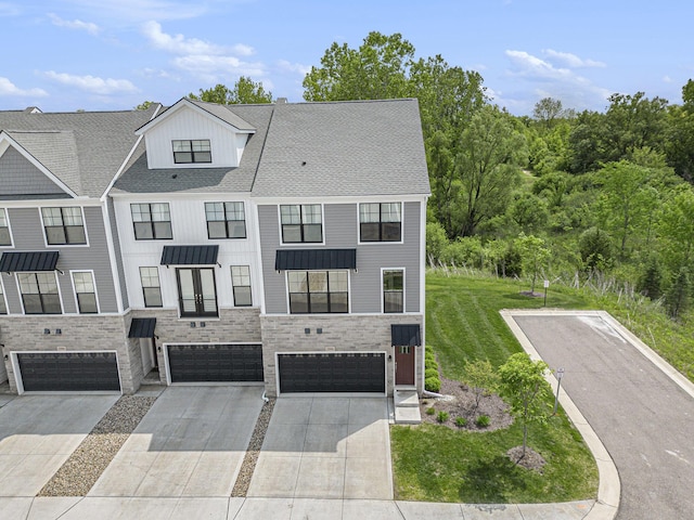 2990 Stoke Way, Ann Arbor, MI 48105 - view of property with driveway, an attached garage, stone siding, a standing seam roof, and a front lawn