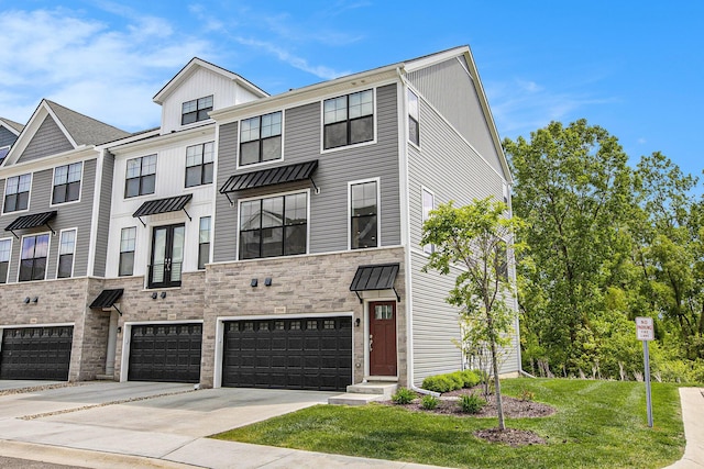2990 Stoke Way, Ann Arbor, MI 48105 - multi unit property featuring an attached garage, driveway, stone siding, a front yard, and board and batten siding