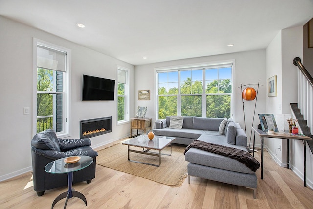 2990 Stoke Way, Ann Arbor, MI 48105 - living room featuring stairs, wood finished floors, baseboards, a glass covered fireplace, and recessed lighting