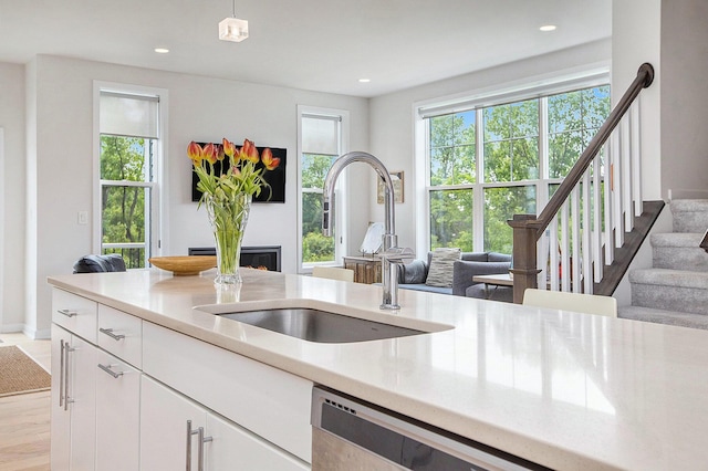 2990 Stoke Way, Ann Arbor, MI 48105 - kitchen with a sink, light countertops, open floor plan, a warm lit fireplace, and recessed lighting