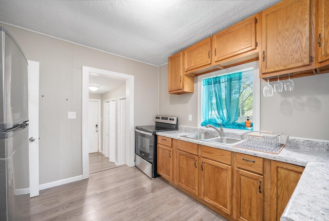 64 E Grand Circle Ave, Battle Creek, MI 49037 - kitchen featuring appliances with stainless steel finishes, a sink, light countertops, light wood-type flooring, and a textured ceiling