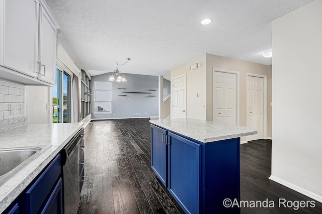 648 Firestone Dr SE, Byron Center, MI 49315 - kitchen with blue cabinets, dark wood-style flooring, a textured ceiling, a chandelier, and light countertops