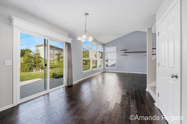 648 Firestone Dr SE, Byron Center, MI 49315 - unfurnished dining area with a chandelier, hardwood / wood-style floors, baseboards, lofted ceiling, and a textured ceiling