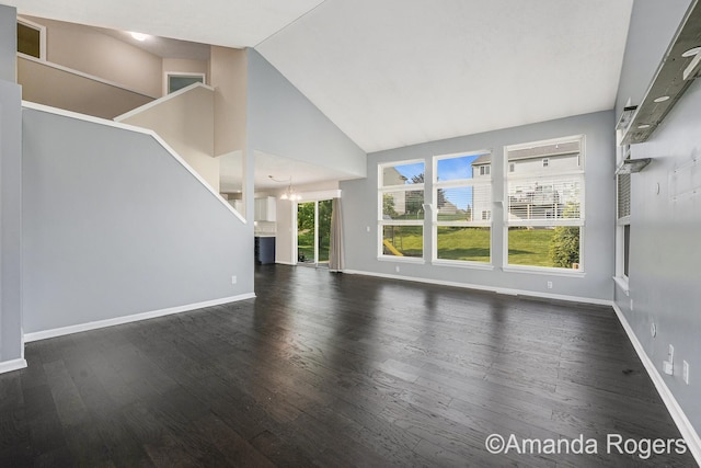 648 Firestone Dr SE, Byron Center, MI 49315 - unfurnished living room featuring wood finished floors, a chandelier, baseboards, stairs, and high vaulted ceiling