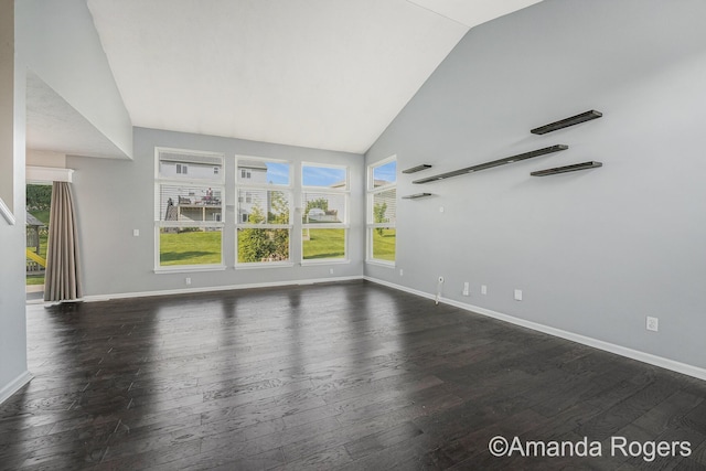 648 Firestone Dr SE, Byron Center, MI 49315 - unfurnished living room featuring dark wood-type flooring, baseboards, and high vaulted ceiling