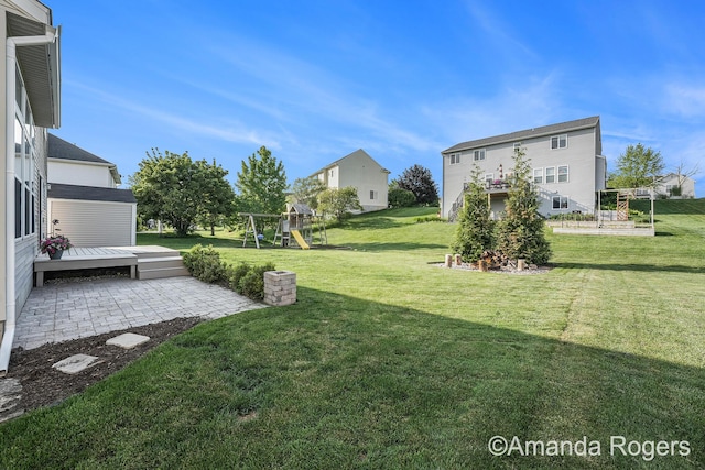 648 Firestone Dr SE, Byron Center, MI 49315 - view of green lawn featuring a playground, a patio area, and a deck