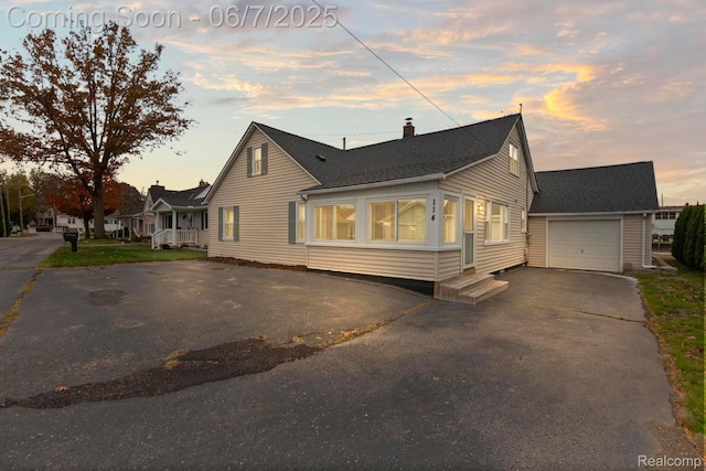 114 Interlochen Dr, Algonac, MI 48001 - view of front of property featuring driveway, a garage, a chimney, and a shingled roof