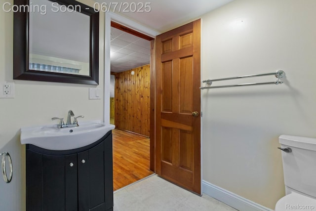 114 Interlochen Dr, Algonac, MI 48001 - half bath with toilet, vanity, wooden walls, baseboards, and a drop ceiling
